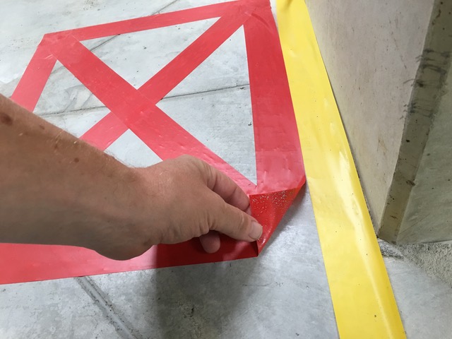 Detail ručného odstraňovania červenej pásky